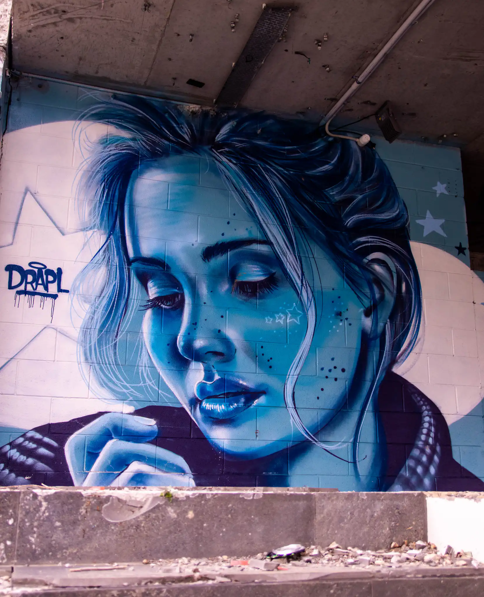 Woman with blue tinted face painted by Drapl