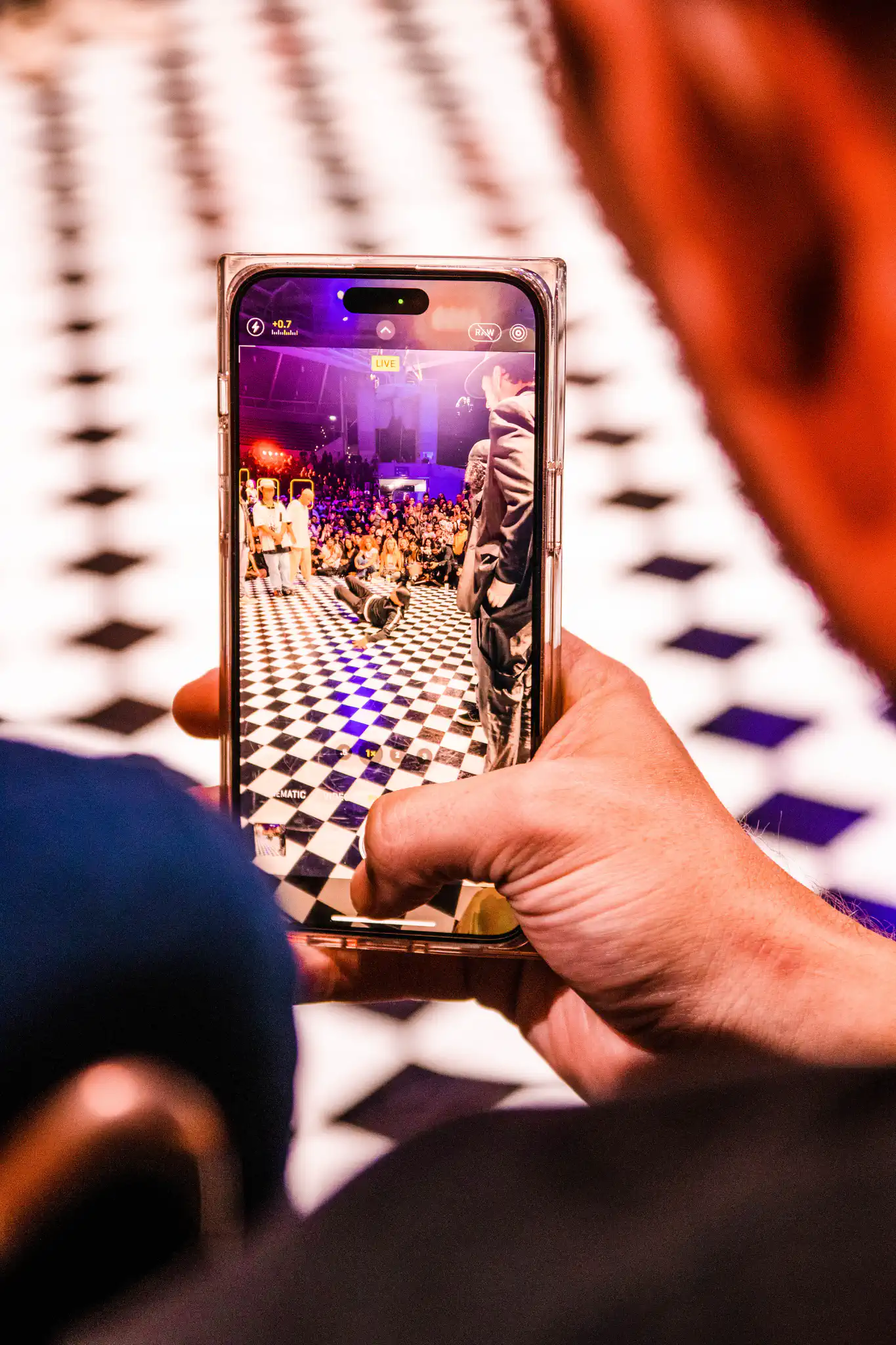 Person filming Battles and Jams venue on smartphone